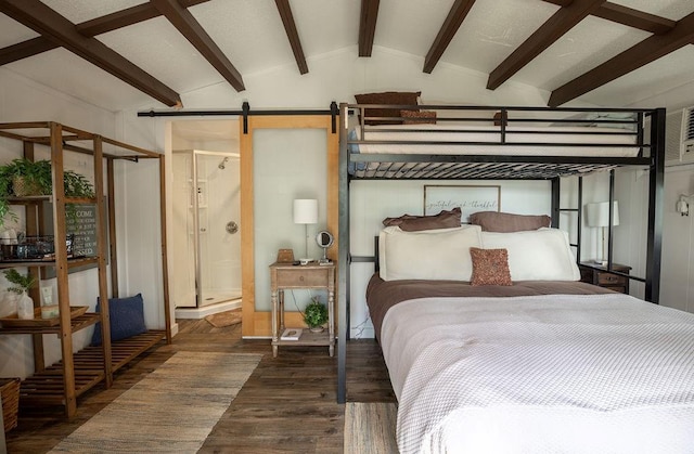 bedroom featuring a barn door, dark wood-type flooring, and lofted ceiling with beams