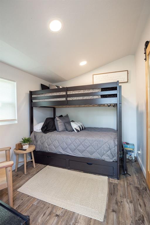 bedroom with wood-type flooring and lofted ceiling