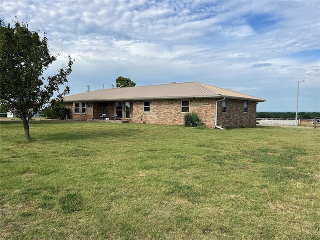 rear view of house featuring a lawn