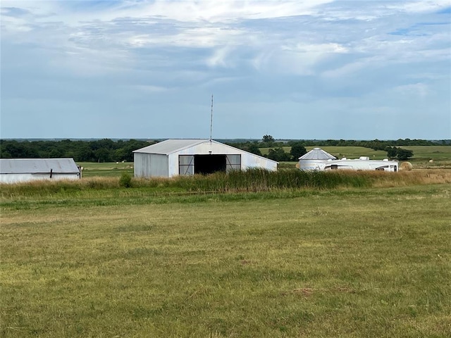 view of yard featuring a rural view and an outdoor structure