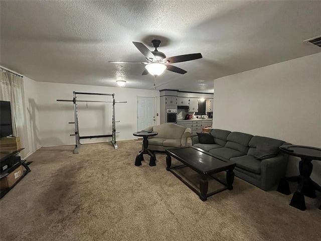 living room featuring ceiling fan, light colored carpet, and a textured ceiling