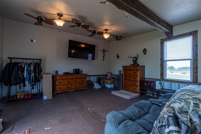 bedroom featuring beamed ceiling, concrete flooring, and ceiling fan