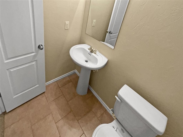 bathroom with toilet and tile patterned floors