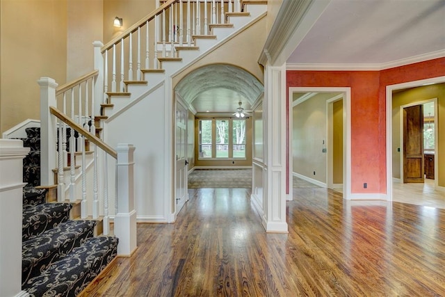 foyer featuring hardwood / wood-style flooring, ornate columns, ceiling fan, and crown molding