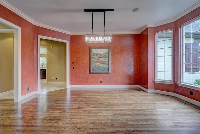 unfurnished dining area featuring crown molding, light hardwood / wood-style flooring, a healthy amount of sunlight, and a notable chandelier