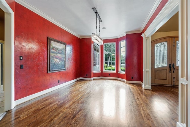 unfurnished dining area with wood-type flooring, ornamental molding, and a chandelier