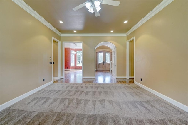 unfurnished room featuring light carpet, french doors, ceiling fan, and ornamental molding