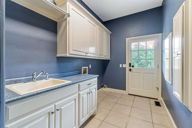 laundry room with cabinets, sink, light tile patterned floors, and washer hookup