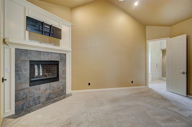 unfurnished living room featuring carpet flooring, a tile fireplace, and lofted ceiling