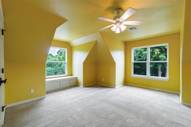 additional living space featuring a wealth of natural light, ceiling fan, light carpet, and vaulted ceiling