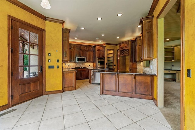 kitchen featuring a peninsula, dark countertops, tasteful backsplash, appliances with stainless steel finishes, and light tile patterned floors