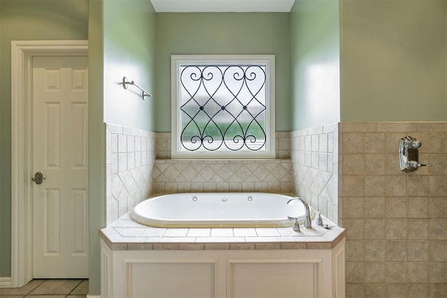 bathroom with a garden tub and tile patterned flooring