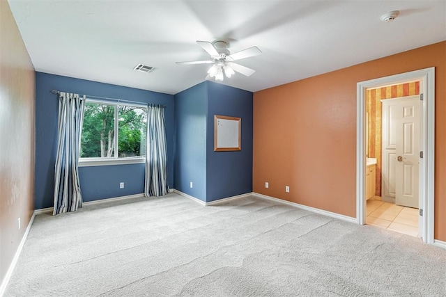 unfurnished room featuring baseboards, visible vents, ceiling fan, and carpet flooring