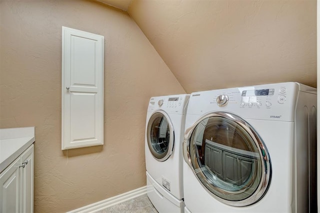 laundry area with washer and clothes dryer, cabinet space, a textured wall, and baseboards