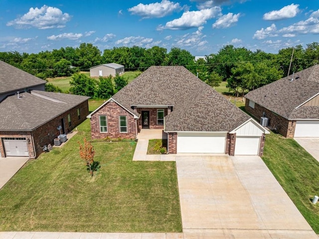 view of front of property featuring a garage, concrete driveway, roof with shingles, a front lawn, and brick siding