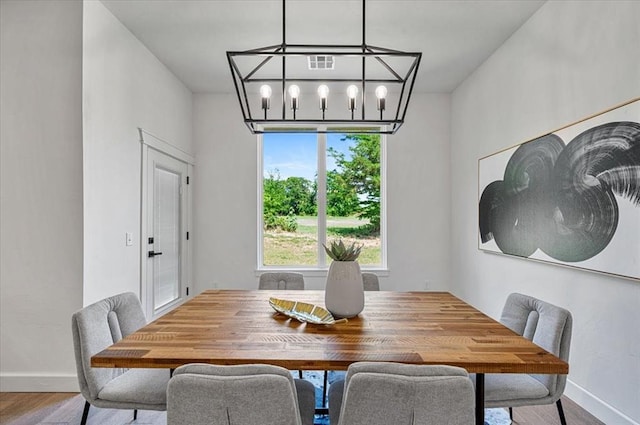 dining area featuring hardwood / wood-style flooring and a chandelier