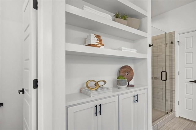 bathroom with wood-type flooring and walk in shower