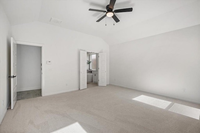 unfurnished bedroom with ensuite bath, light colored carpet, vaulted ceiling, and ceiling fan