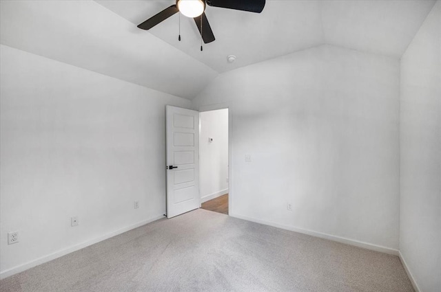 carpeted spare room with vaulted ceiling and ceiling fan