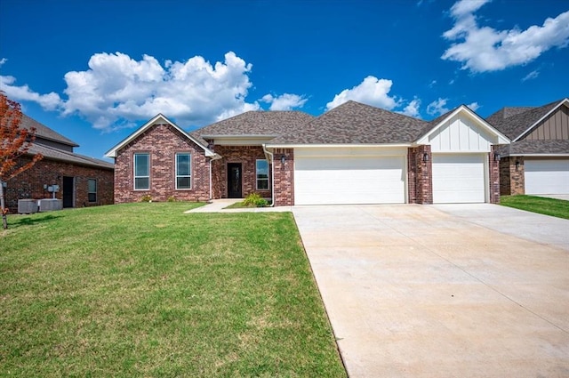 view of front of property with central AC unit, a garage, and a front lawn