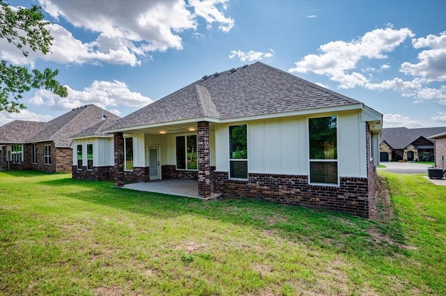 rear view of property featuring a yard and a patio