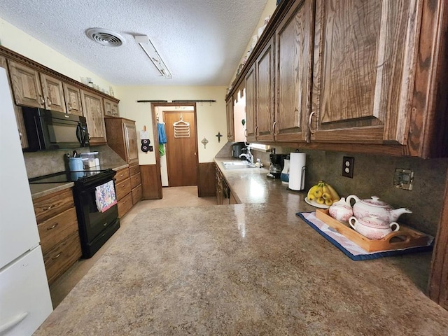 kitchen featuring black appliances, sink, and a textured ceiling