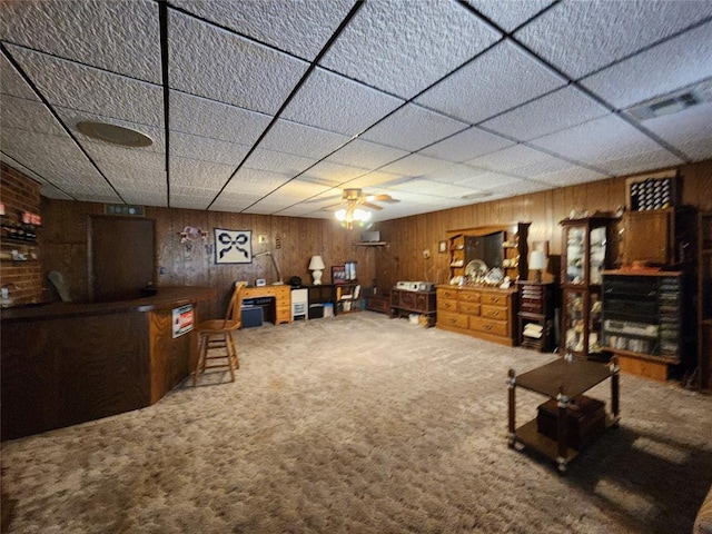 living room featuring carpet, wood walls, and ceiling fan