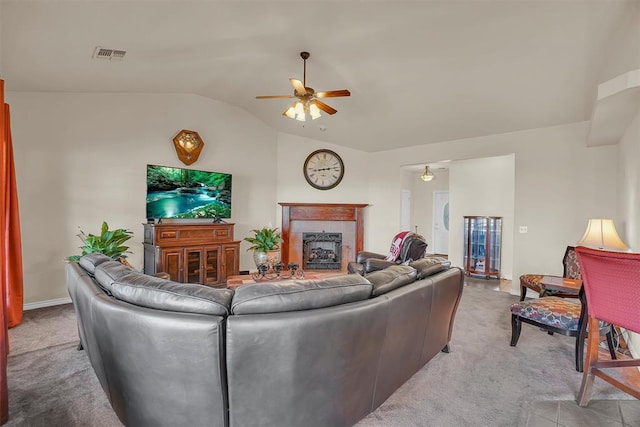 living room featuring a tiled fireplace, ceiling fan, light colored carpet, and lofted ceiling