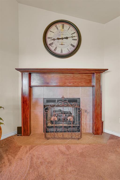 interior details with a tile fireplace and carpet floors