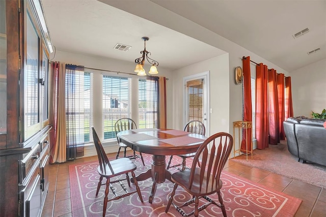 dining space featuring a chandelier and dark tile patterned flooring