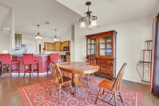 tiled dining space with an inviting chandelier and lofted ceiling