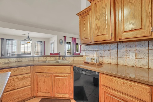 kitchen featuring tasteful backsplash, dishwasher, decorative light fixtures, and sink