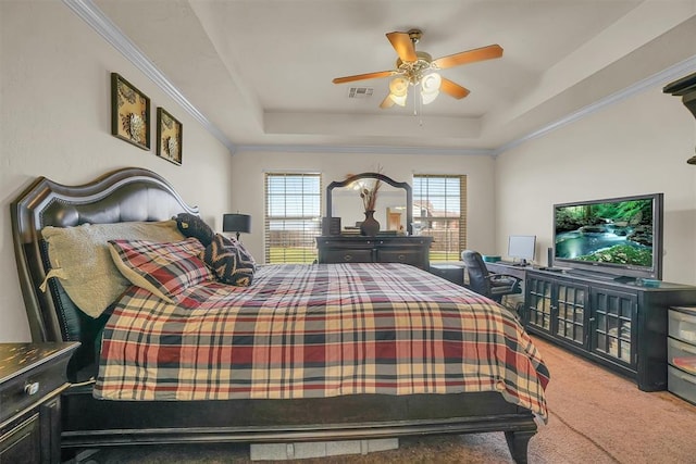 carpeted bedroom featuring a tray ceiling, ceiling fan, and crown molding