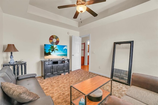 living room featuring ceiling fan and a tray ceiling