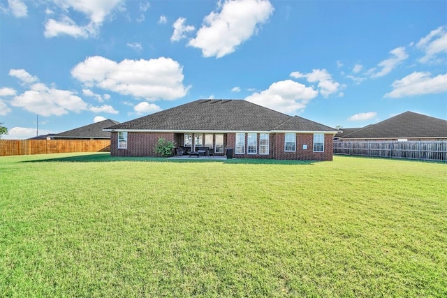 back of house featuring a patio area and a yard