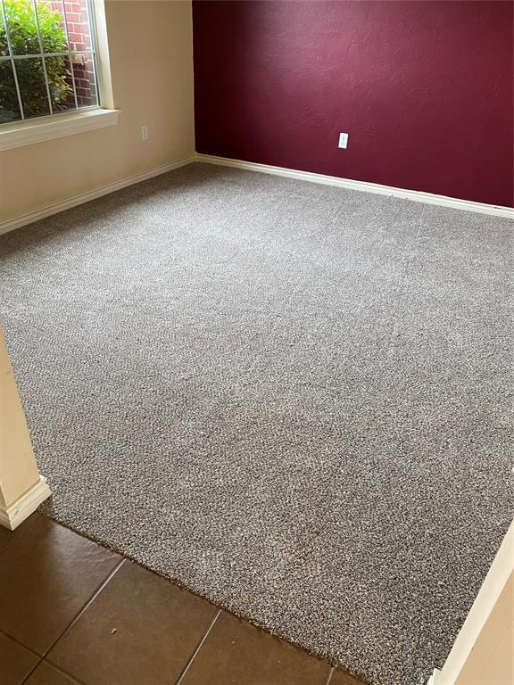 unfurnished room featuring baseboards and carpet