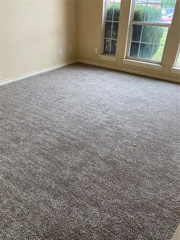 carpeted spare room with baseboards