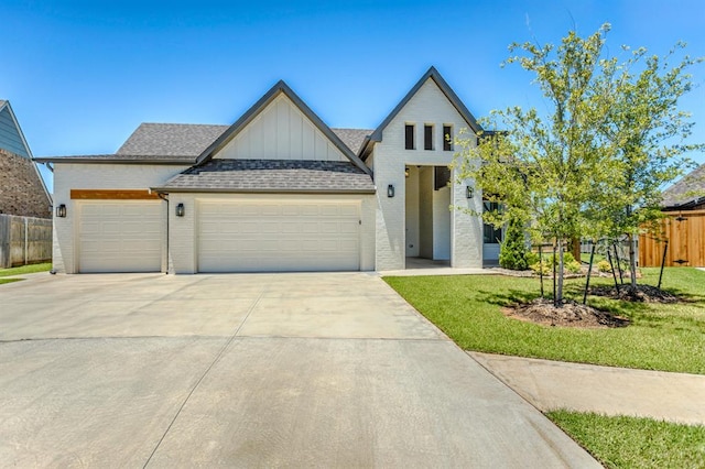 modern farmhouse with brick siding, board and batten siding, fence, a garage, and driveway