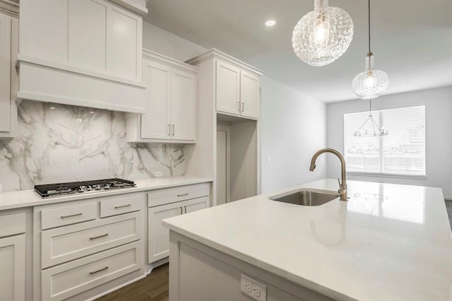 kitchen featuring tasteful backsplash, white cabinets, decorative light fixtures, and stainless steel gas stovetop