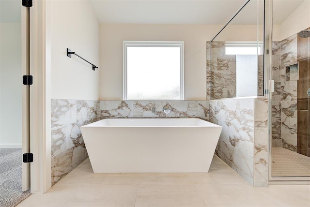 2405 Crystal Creek Dr, Yukon, OK 73099 - bathroom featuring healthy amount of natural light, tile walls, a freestanding tub, a stall shower, and a wainscoted wall