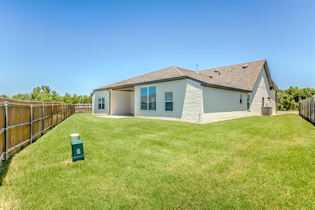 rear view of property with a lawn and central AC