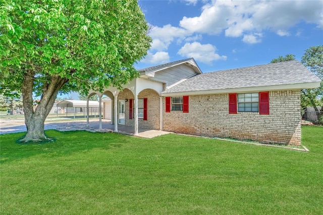 view of front of home with a carport and a front yard