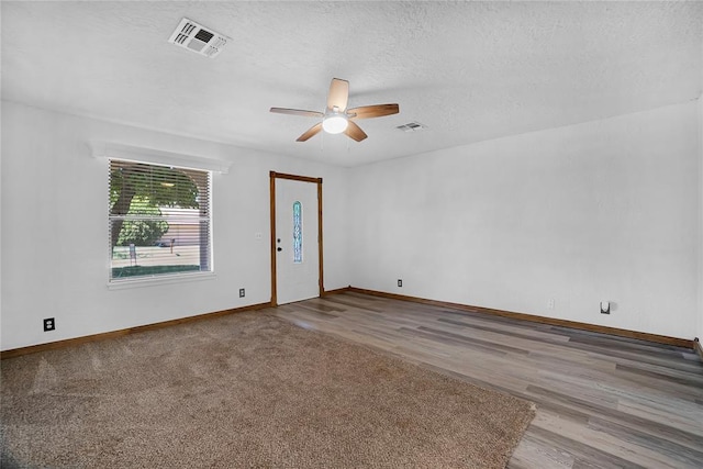 unfurnished room featuring ceiling fan, a textured ceiling, and light wood-type flooring