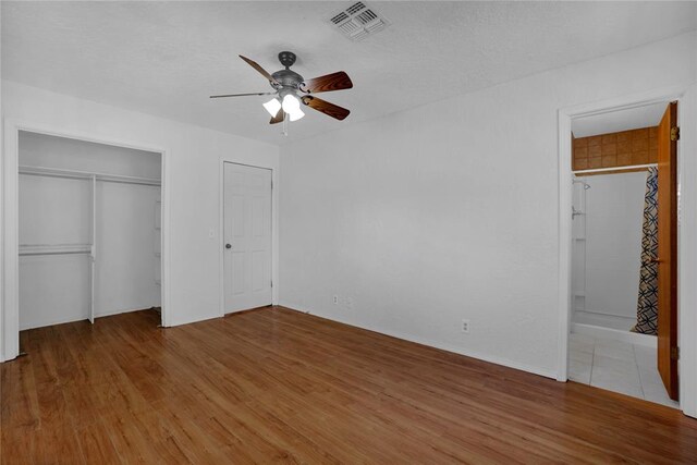 unfurnished bedroom featuring a textured ceiling, light hardwood / wood-style floors, and ceiling fan