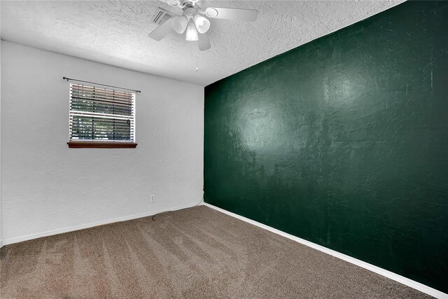 carpeted empty room with ceiling fan and a textured ceiling