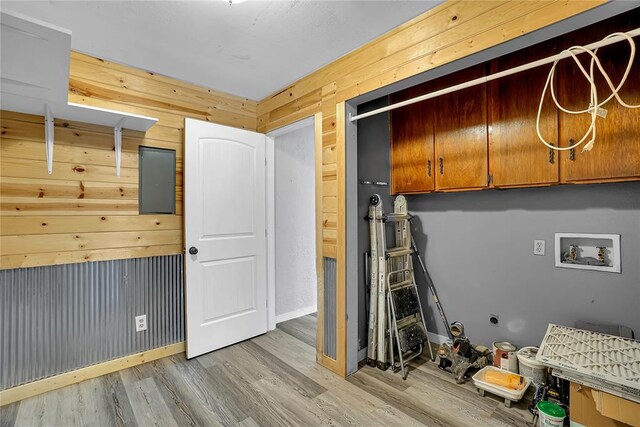 laundry room with wooden walls, cabinets, light hardwood / wood-style floors, and washer hookup