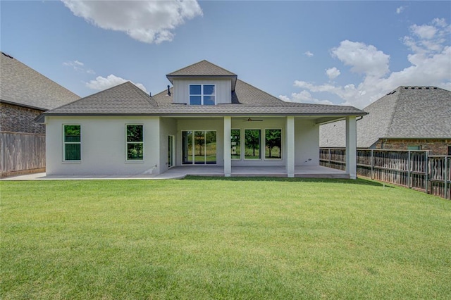 back of house with ceiling fan, a yard, and a patio