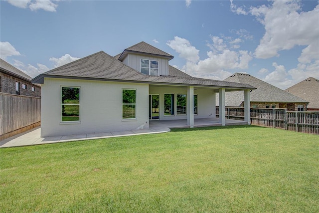 back of house with a lawn and a patio