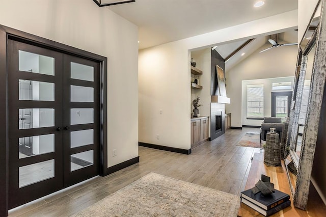 entrance foyer with french doors, vaulted ceiling, light hardwood / wood-style flooring, and ceiling fan