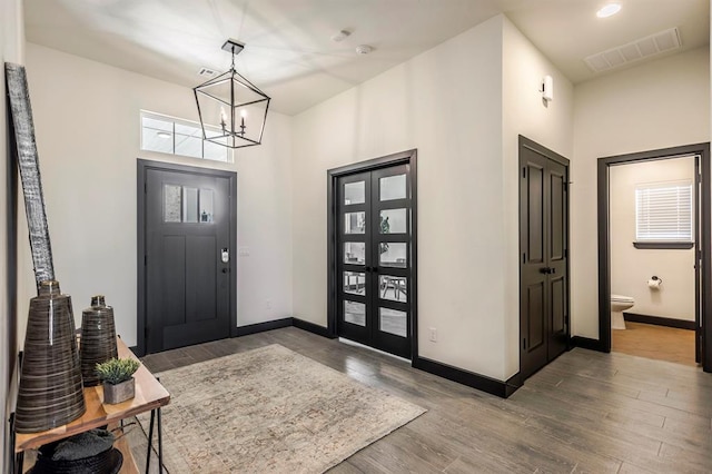 foyer entrance with dark wood-type flooring and a chandelier